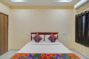 Una cama con dos almohadas encima en una habitación. en FabHotel PVR, en Hyderabad