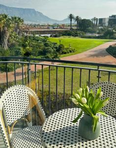 a table with chairs and a vase of flowers on a balcony at ON PARK 317 LUXURY APARTMENT CENTURY CiTY in Century City
