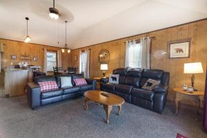 un salon avec deux canapés en cuir et une table dans l'établissement Mountain Overlook Supercabin, à Rileyville
