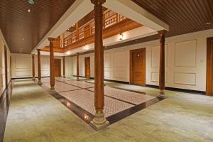 a large room with columns and a wooden ceiling at AKG Hotel in Pondicherry
