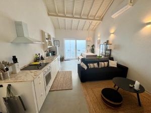 Una cocina y una sala de estar con un sofá y una mesa. en Scandi-inspired Cottage - Comporta Beach - Alentejo Tranquility, 