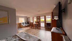 a living room with a bed and a dining room at Pokoje Wczasowe Barbara in Ustka