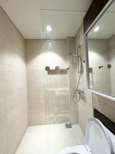 a bathroom with a glass shower with a toilet at Tambuli Seaside Living Condominium -Private Host Tower D in Maribago +8 photos