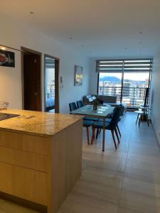 eine Küche und ein Wohnzimmer mit Tisch und Stühlen in der Unterkunft Premium Suite República del Salvador in Quito