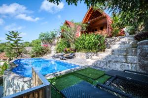 a swimming pool in a yard with a house at Adinata Villa by Manara in Seraya +20 photos