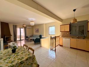 a kitchen and a living room with a table and a dining room at Anavyssos Azure in Anavissos +15 photos