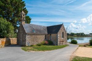 Una antigua iglesia de piedra con una torre en un lago en Residence mer et pins, en Saint-Philibert