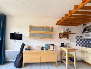 a kitchen with a wooden desk and a table at Métamorphose au sommet, studio au pied des pistes in Villard-de-Lans +4 photos