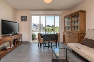 Una sala de estar con un sofá y una mesa con televisión. en Residence mer et pins, en Saint-Philibert