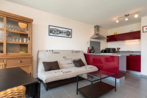 Una sala de estar con un sofá y una cocina. en Residence mer et pins, en Saint-Philibert