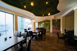 a restaurant with tables and chairs and a green ceiling at Perla Crasnei in Crasna