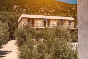 a house on a hill with trees in front of it at Eman Resort & Villas in Ulcinj
