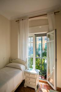a bedroom with a bed and a large window at Pensión Dulces Sueños in Seville