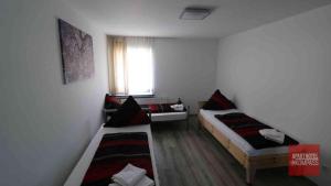 two beds in a small room with a window at Aparthotel Kompass A 201 in Essen +5 photos