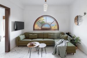 a living room with a green couch and a table at MUSES CHALKIDIKI #Skgbnb in Mesochórion