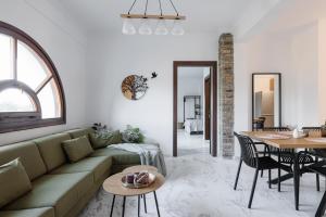 a living room with a green couch and a table at MUSES CHALKIDIKI #Skgbnb in Mesochórion