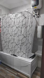 a bathroom with a white and black shower curtain at Keev Homes 2 bedroom Apartment in Port Harcourt