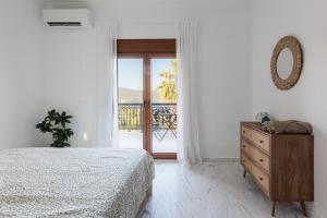 a bedroom with a bed and a door to a balcony at MUSES CHALKIDIKI #Skgbnb in Mesochórion