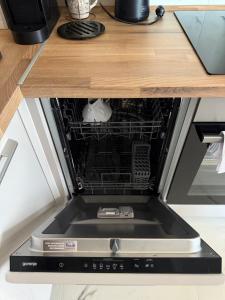 Un lavavajillas abierto con la puerta abierta en una cocina. en Bar Seaview Escape, en Bar