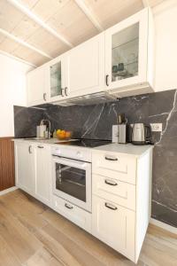 a kitchen with white cabinets and a counter top at Green Terrace in Cernobbio center in Cernobbio