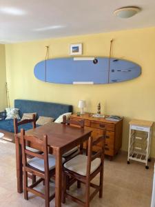 a dining room with a table and a surfboard on the wall at Confortable Apartment in Corralejo in Corralejo +8 photos