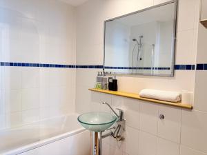 a bathroom with a sink and a mirror and a tub at PostBox Apartments in Birmingham City Centre Near Birmingham Canal in Birmingham