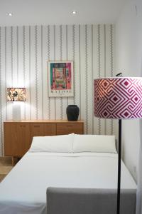 a bedroom with a bed and a table with a lamp at AvantiStays Capote in Seville +7 photos