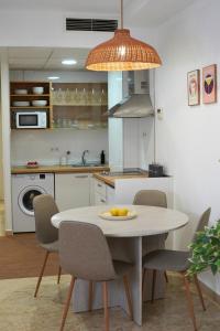 a kitchen with a white table with chairs and a sink at AvantiStays Capote in Seville
