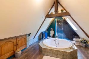 a bathroom with a large tub in a attic at Maison de campagne dans le Périgord in Anlhiac +17 photos