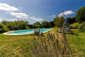 a swimming pool in a grassy field with at Maison de campagne dans le Périgord in Anlhiac