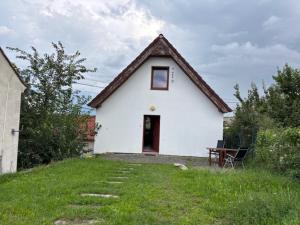 a small white house with a grassy yard at Apártmány Sedlec in Sedlec