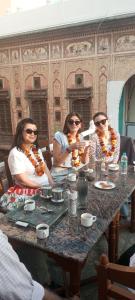 a group of three women sitting at a table at Hotel Singhasan haveli in Mandāwa