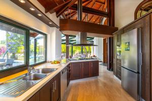 a kitchen with wooden cabinets and a large window at Cottage House - Adult Only in Antalya