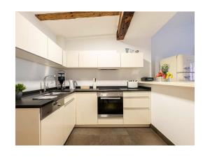 a kitchen with white cabinets and a sink at Lebenslust in Konstanz +2 photos