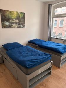 two twin beds in a room with a window at Neu saniertes Apartment in Magdeburg in Magdeburg