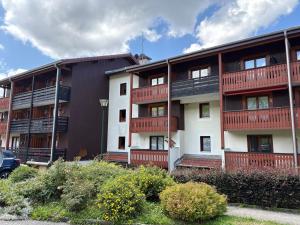 un immeuble avec balcon rouge dans l'établissement Appartement Duplex, à Habère-Poche