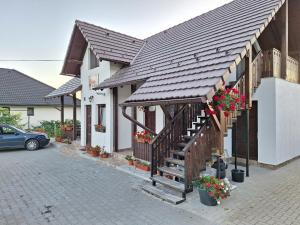 a house with a staircase and flowers on it at Casa Muskátli Vendégház in Sovata