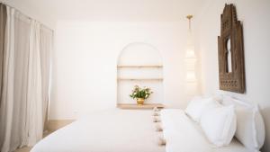 a white bedroom with a white couch and a window at Riad Dar Mimi in Marrakech