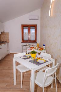 a white kitchen with a white table and white chairs at Il Nibbio Reale in Albano di Lucania