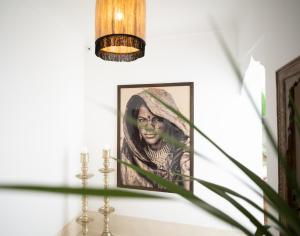 a picture of a woman on a wall with a candle at Riad Dar Mimi in Marrakech