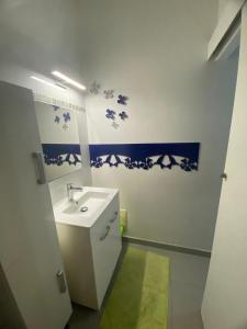 a bathroom with a sink and blue and white walls at Maison en résidence privée avec piscine accès plage in Les Trois-Îlets