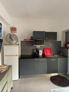 a kitchen with a white refrigerator and a microwave at Maison en résidence privée avec piscine accès plage in Les Trois-Îlets