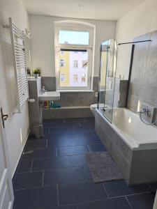a bathroom with a tub and a sink at Neu saniertes Apartment in Magdeburg in Magdeburg