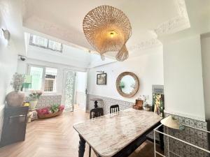 a dining room with a table and a large chandelier at Cherry Blossom Boutique Hotel Entire House Bui Vien in Ho Chi Minh City