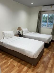 two beds in a room with two windows at AJ Pizza and Steakhouse in Ban Khai Nun +38 photos