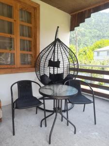two chairs and a table with a bird cage at Guesthouse ''Kavkasioni'' in Glola