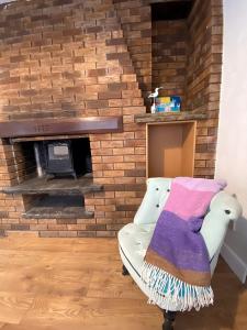 a living room with a brick fireplace with a couch at 4-Bedrooms - Perfect for those working in Bridgend in Bridgend