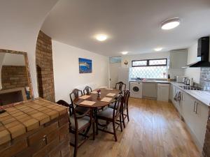 a kitchen and dining room with a table and chairs at 4-Bedrooms - Perfect for those working in Bridgend in Bridgend +13 photos