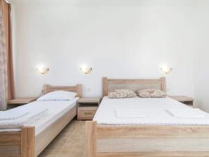 two beds in a room with white walls at Villa INA in Kaluđerac +38 photos