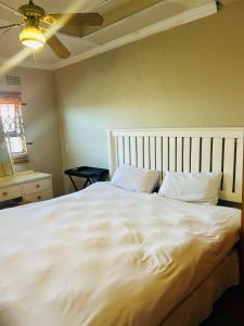 a large white bed in a bedroom with a ceiling at Konayethu BnB in Mdantsane +20 photos